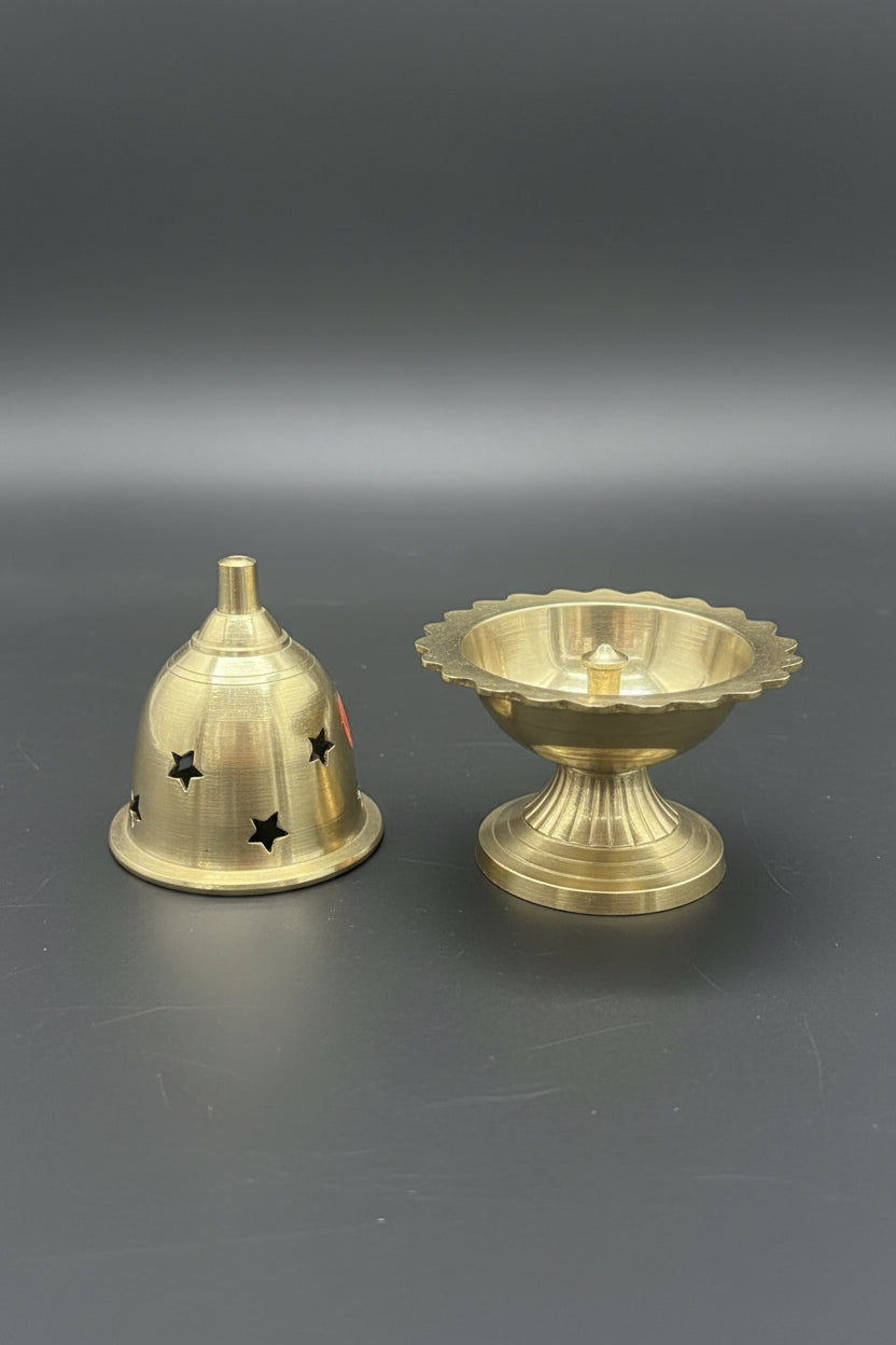 A pair of brass oil lamps, one shown assembled and the other disassembled to reveal its dome-shaped shade with decorative cutouts, on a plain white background.